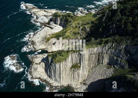 Photo aérienne du cap Stolbchaty sur Kunashir isl. De Kuril Ridge par une journée ensoleillée.Les formations volcaniques du fond marin sont clairement visibles à marée basse. Banque D'Images