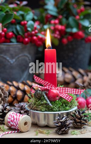décoration de noël avec bougie rouge dans moule de cuisson vintage Banque D'Images