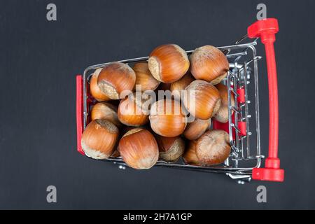 Noisettes nutritives dans un panier et dispersées sur le sol. Noisettes dans un panier. Orishki sain et diététique dans le panier. Wi en arrière-plan Banque D'Images