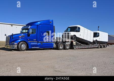 EMPORIA, Kansas, novembre 21 :Deux tout nouveaux modèles EDV 500 Rivan Electric Delivery Vans (EDV) faisant partie de la commande de parc pour Amazon à l'arrière d'un camion de transport pour petits garçons stationné dans le Knights Inn Motel lors d'un voyage de l'usine de production de Normal Illinois à leur destination finale le 21 novembre,2021 à Emporia, Kansas.Crédit : Mark Reinstein/MediaPunch Banque D'Images