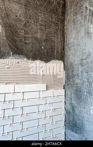 Installation de carreaux de métro dans une cabine de douche Banque D'Images