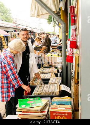 Les visiteurs qui choisissent des disques en vinyle vendus dans des boîtes dans la cabine extérieure d'Udelka Udelnaya fullent marché, le plus grand dans la ville de Saint-Pétersbourg, Russie Banque D'Images