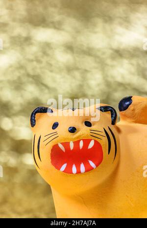 Carte de vœux du nouvel an japonais représentant un gros plan sur le visage mignon d'un animal zodiac, figurine artisanale du tigre pour 2022 frondement contre un g Banque D'Images