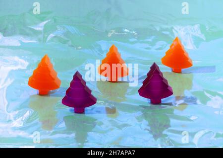 Trois arbres de Noël orange et deux arbres de Noël violets sur fond holographique.Concept créatif futuriste rétro pour Noël ou le nouvel an carte ou bannière ou Banque D'Images