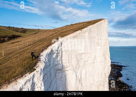 Jeune homme debout sur les falaises blanches de Douvres. Banque D'Images