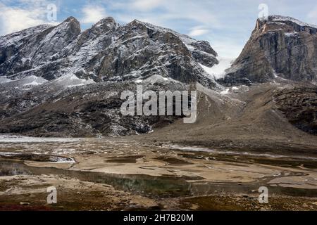 Montagnes enneigées, petit glacier et vallée fluviale, Milne Land, Scoresby Sund, Groenland Banque D'Images