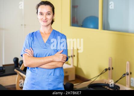 Physiothérapeute femme confiante en réadaptation avec équipement de pilates Banque D'Images