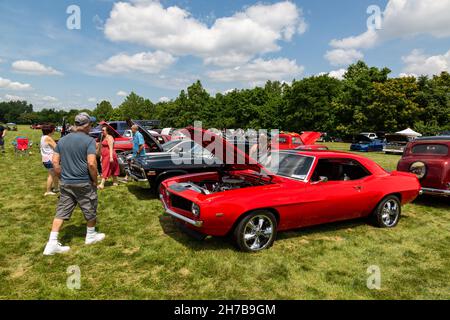 Un homme s'approche d'un coupé rouge Camaro 1969 de Chevrolet exposé avec le capot relevé lors d'un salon de l'auto à fort Wayne, Indiana, États-Unis. Banque D'Images