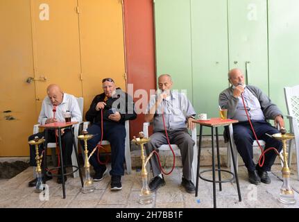 Les hommes fumeurs Nargila palestinienne dans la vieille ville de Jérusalem. Banque D'Images