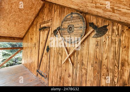 La porte d'entrée de la cabane où la taverne ou le pub est situé avec un bouclier épique et des haches croisées comme un salut Banque D'Images