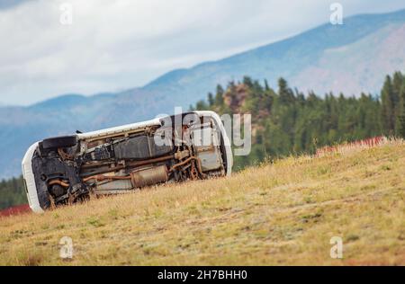 L'accident a impliqué un retournement de voiture hors de l'autoroute se trouvant sur un côté entre les herbes. Banque D'Images