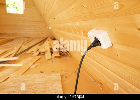 Prise électrique dans une maison en bois en construction.Le concept de sécurité incendie dans le chalet Banque D'Images