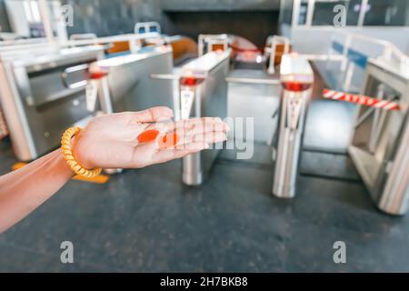 Un jeton de billet dans la main du passager avant de passer par le tourniquet dans le métro Banque D'Images