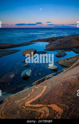 Lune et crépuscule le matin de novembre sur la côte rocheuse près du fjord d'Oslofjord, à Larkollen, Østfold, Norvège, Scandinavie. Banque D'Images