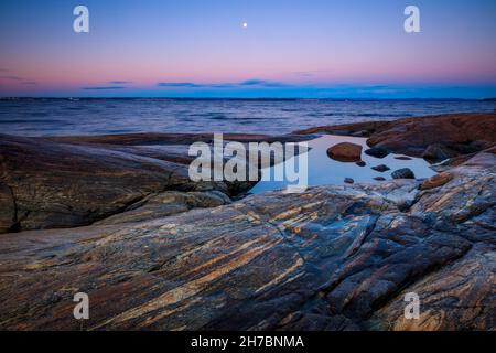 Lune et crépuscule le matin de novembre sur la côte rocheuse près du fjord d'Oslofjord, à Larkollen, Østfold, Norvège, Scandinavie. Banque D'Images