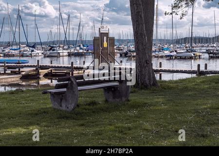 Mardorf, Basse-Saxe, Allemagne - 07 juin 2020 : banc sur la rive du Steinhuder Meer avec une jetée et la Marina en arrière-plan Banque D'Images