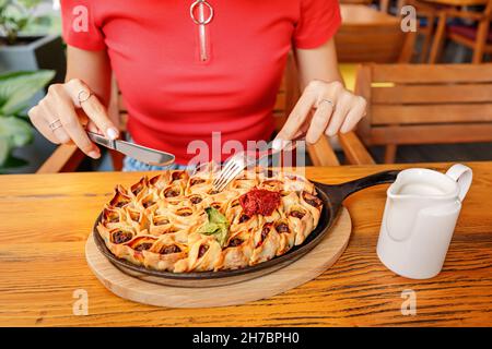 Femme mangeant des manti ou des boulettes ouvertes dans une poêle au restaurant.Cuisine traditionnelle des peuples oriental et turc Banque D'Images