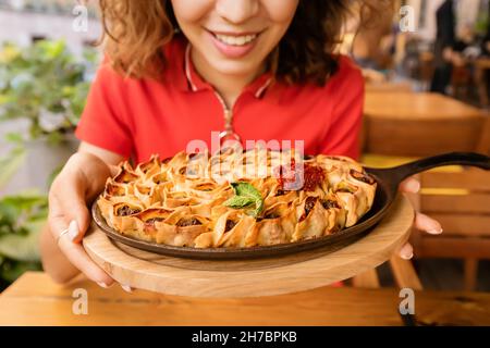 Femme mangeant des manti ou des boulettes ouvertes dans une poêle au restaurant.Cuisine traditionnelle des peuples oriental et turc Banque D'Images