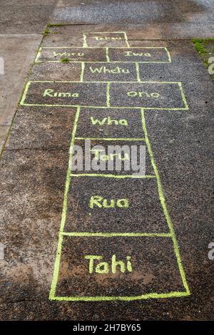 Te Reo (langue maorie) Hopscotch jeu sur un bord de route Banque D'Images