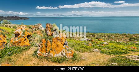 Paysage idyllique avec des rochers orange pittoresques et le célèbre lac de Sevan - l'une des plus grandes sources d'eau douce en Arménie et dans toute la Transcaucasie. Banque D'Images