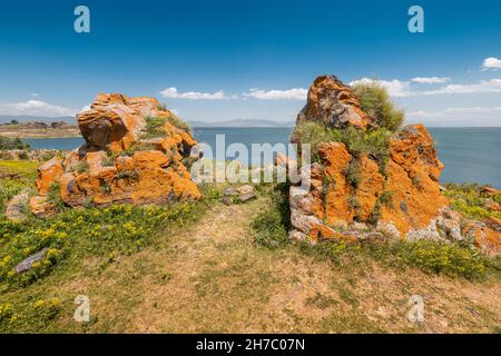 Paysage idyllique avec des rochers orange pittoresques et le célèbre lac de Sevan - l'une des plus grandes sources d'eau douce en Arménie et dans toute la Transcaucasie. Banque D'Images