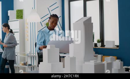 Femme constructeur analyse des plans de conception du plan de construction et du modèle de construction.Architecte utilisant la maquette et la structure de propriété pour construire un projet immobilier urbain. Banque D'Images