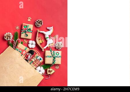 Boîtes cadeau rouges et vertes enveloppées à la main, ornées de rubans, flocons de neige et chiffres, décorations de Noël et décoration en sac sur table rouge Noël Avent Banque D'Images