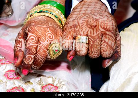 Les jeunes mariés tiennent et montrent des bagues de bijoux de mariage Banque D'Images