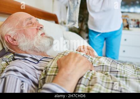 Malade senior avec canule d'oxygène dans le lit à l'hôpital ou dans les soins à domicile Banque D'Images