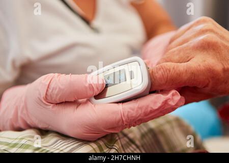 Oxymètre de pouls sur le doigt du patient pour mesurer le pouls et la saturation en oxygène Banque D'Images