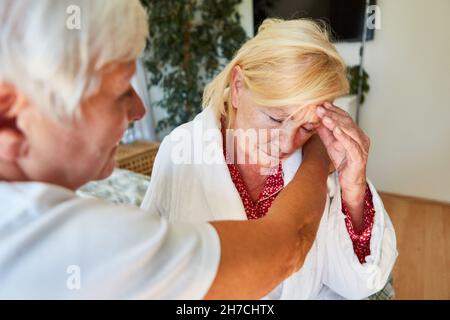 Console de travailleur de soins aux personnes âgées une femme âgée séniée ou solitaire à la maison Banque D'Images