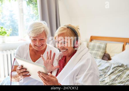 Heureux senior citoyen agitant à la webcam pendant le chat vidéo avec un ami ou un soignant Banque D'Images