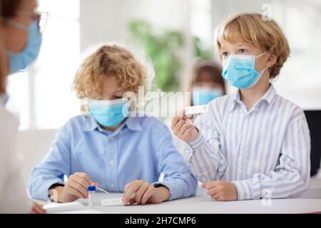 Test Covid-19 à l'école.Dépistage rapide de l'antigène du coronavirus pour les élèves en classe.Kit de test d'écouvillon pour enfant en classe. Banque D'Images