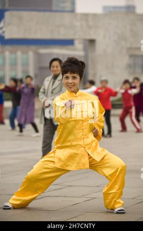 Femme en vêtements de Tai Chi faisant matin Tai Chi au Bund sur Zhongshan Road, Chine, Shanghai Banque D'Images