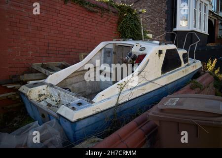 Vieux petit bateau de pêche couché inutilisé dans un jardin New Brighton le Wirral merseyside royaume-uni Banque D'Images