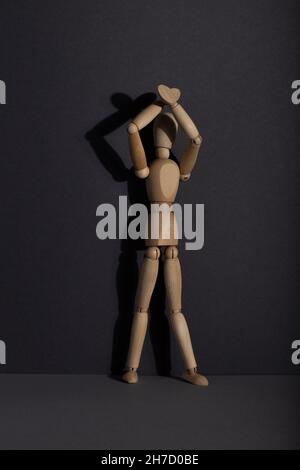 Supports de mannequin en bois avec mains levées sur fond gris. Protestation, concept d'attention. Espace de copie, lumière dure. Banque D'Images