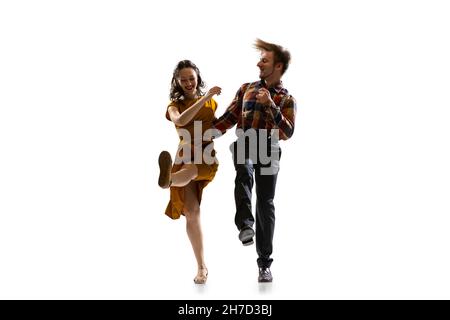 Portrait dynamique de danseurs élégants, jeune homme et femme en tenue vintage dansant balançoire isolée sur fond blanc Banque D'Images