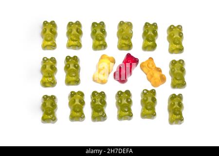 Des rangées d'ours verts délicieux dans lesquels un rouge et deux jaunes se comportent différemment du concept de l'individualité et d'être différents isolés sur un coup Banque D'Images