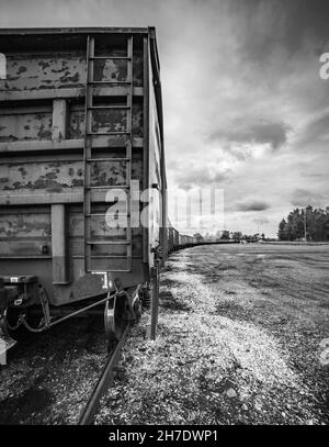 Train de wagons de camions-citernes noirs transportant du pétrole brut sur les voies, avec filtre de style instagram Banque D'Images