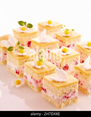 Petits fours à la framboise avec crème mascarpone, fondant, massepain, abricots et menthe Banque D'Images