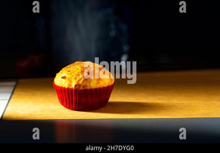 un cupcake est photographié avec une petite lumière dans le studio sur un fond de papier ancien.Cuisine maison Banque D'Images