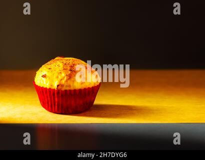 un cupcake est photographié avec une petite lumière dans le studio sur un fond de papier ancien.Cuisine maison Banque D'Images