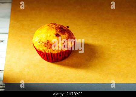 un cupcake est photographié avec une petite lumière dans le studio sur un fond de papier ancien.Cuisine maison Banque D'Images