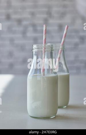 Bouteilles de lait avec pailles roses Banque D'Images