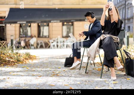 Homme d'affaires travaille sur un ordinateur portable et femme va en ville Banque D'Images