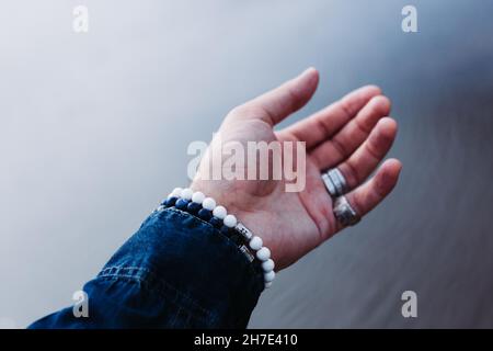 Paume ouverte d'un homme portant des bracelets et des bagues Banque D'Images