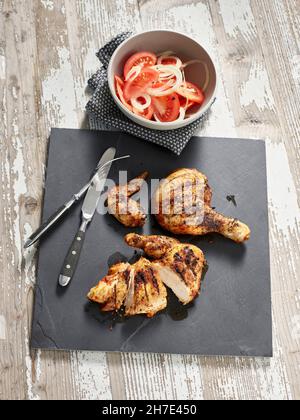 Poulet piri piri avec salade de tomates et d'oignons Banque D'Images