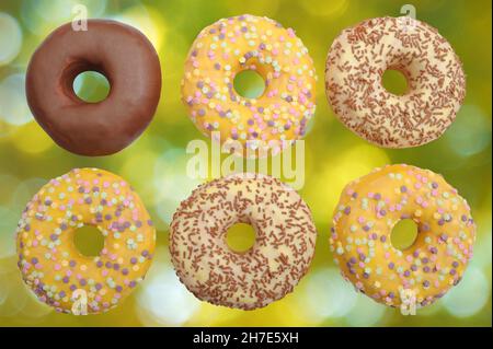 Délicieux, beaux beignets au caramel au sucre, glaçure de chocolat de couleur, éléments décoratifs, isolés sur un fond de bokeh jaune-vert Banque D'Images