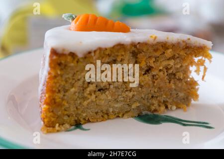 Une tranche de gâteau de carotte avec glaçage et carottes de massepain Banque D'Images