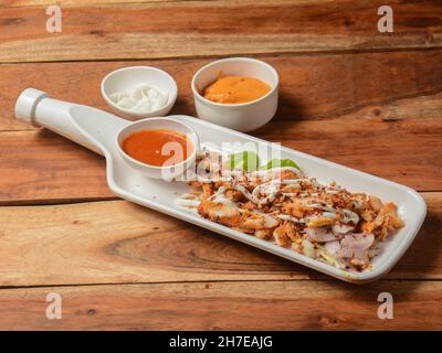 Plateau de poulet shawarma servi sur fond de bois rustique.Plats et hors-d'œuvre de cuisine indienne, sélection Banque D'Images